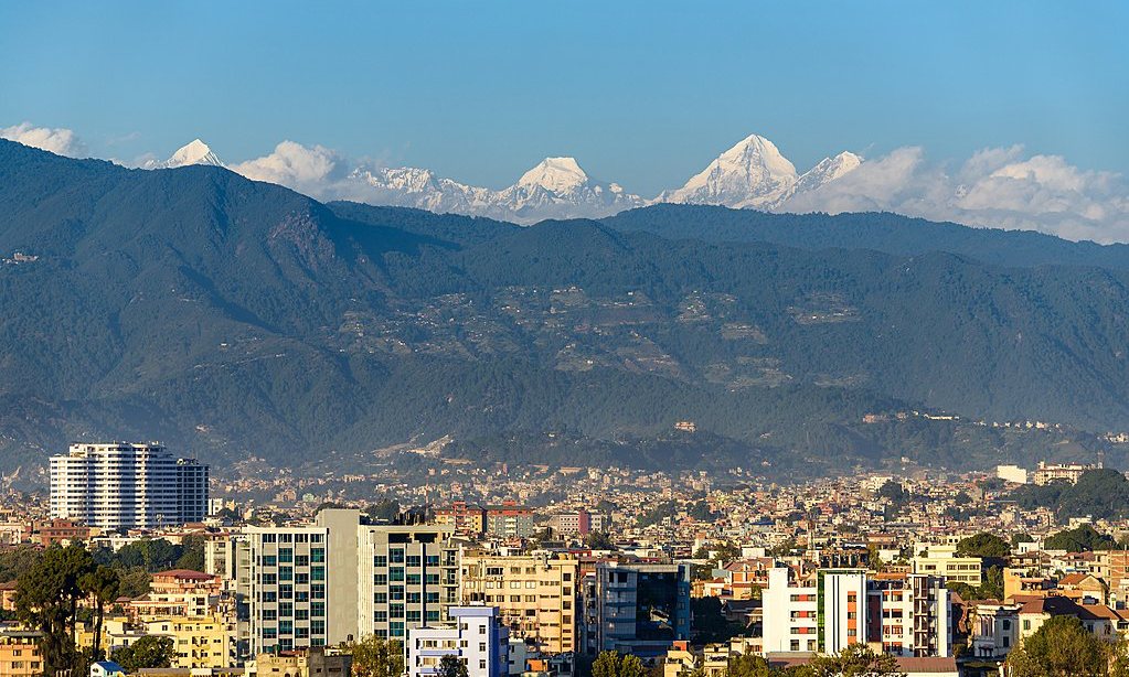 Snow-capped Himalayan peaks rising above the hills and rooftops of the Kathmandu valley