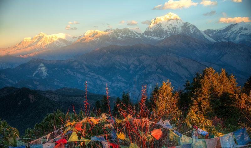 Himalayan panorama with prayer flags at sunrise, the kind of view that rewards the Shivapuri Peak climb